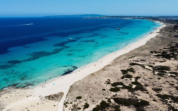 Formentera is the smallest of the Balearic Islands, and Ses Illetes is often cited as one of the best beaches in Europe. Its powdery white sand and shallow, crystal-clear turquoise waters resemble the Caribbean. This tranquil paradise is a haven for those looking to escape the party scene of Ibiza, offering a pristine and natural environment perfect for swimming and witnessing spectacular island sunsets.