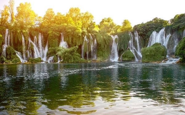 Often called the "Mini Niagara," Kravica is a stunning tufa cascade on the Trebižat River. During the summer, the emerald pools at the base are perfect for swimming and picnics. Surrounded by lush greenery, the falls create a cool and refreshing oasis in the Herzegovinian countryside. It is one of the most beautiful natural landmarks in the country, attracting locals and tourists alike.