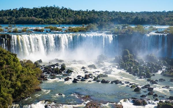 The Iguazu Falls are a massive system of 275 individual waterfalls on the border between Brazil and Argentina. Known for the thunderous "Devil’s Throat," the falls are surrounded by a lush subtropical rainforest teeming with wildlife. Walking along the Brazilian side offers the best panoramic views of the water's immense power, making it one of the most spectacular natural sights in the world.