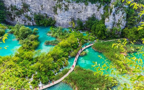 Plitvice Lakes is a UNESCO World Heritage site featuring 16 terraced lakes connected by a series of stunning waterfalls and limestone canyons. Wooden walkways and hiking trails allow visitors to explore the crystal-clear waters that change color from emerald to turquoise. It is a natural wonderland and a highlight of any trip to Croatia.