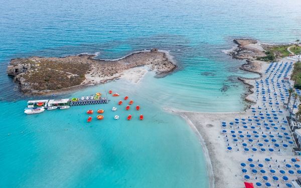 Ayia Napa is famous for its vibrant nightlife and some of the best beaches in Europe. Nissi Beach is particularly iconic for its white sand and a small islet that can be reached by walking through the shallow, crystal-clear water. It is a top destination for sun-seekers, water sports enthusiasts, and those looking for a lively island atmosphere.