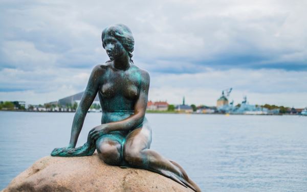 The Little Mermaid statue, perched on a rock by the Langelinie promenade, is a world-famous symbol of Copenhagen inspired by Hans Christian Andersen's fairytale. Despite its small size, it attracts millions of visitors who come to see this iconic bronze figure, which has overlooked the city’s harbor for over a century.