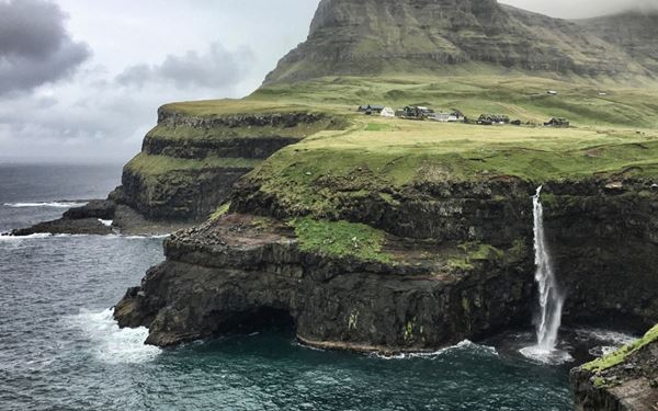 Múlafossur is one of the most iconic sights in the Faroe Islands, located in the village of Gásadalur. The waterfall plunges directly from a high green cliff into the North Atlantic Ocean, with a backdrop of dramatic jagged mountains. It is a breathtaking and picturesque destination that perfectly captures the raw, isolated, and majestic natural beauty of this volcanic archipelago.