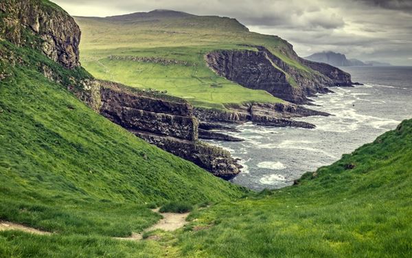 Mykines is the westernmost island of the Faroes and a paradise for birdwatchers. It is world-renowned for its massive colonies of puffins and gannets that nest along its steep cliffs. The hike to the lighthouse across a narrow footbridge provides stunning views of the birdlife and the wild sea. It is a remote and tranquil sanctuary where nature and wildlife remain largely undisturbed by modern life.