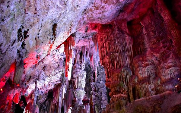 St. Michael's Cave is a spectacular natural limestone cave located within the Rock of Gibraltar. It features impressive stalactites and stalagmites and is now used as a unique natural auditorium for concerts and events. The cave’s dramatic lighting and historic use as a hospital during WWII add to its mystery, making it one of the most popular and awe-inspiring sites for visitors.