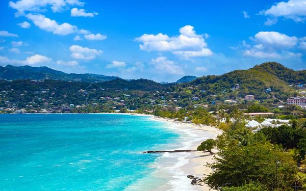 Grand Anse is Grenada's most famous beach, featuring two miles of powdery white sand and calm, sheltered turquoise waters. It is lined with almond trees and world-class resorts, offering a perfect setting for swimming and sunbathing. The beach provides a stunning view of the capital city, St. George's, and is the heart of the island's tourism, known for its quintessential Caribbean beauty.