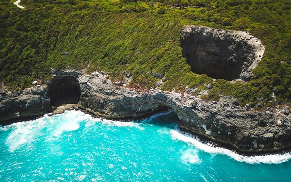 Marie-Galante is a peaceful island known as the "island of a hundred windmills," famous for its traditional rum distilleries and pristine beaches like Anse de la Gourde. It offers a nostalgic glimpse into the past with its ox-drawn carts and slow pace of life. It is the perfect escape for those seeking authentic Caribbean culture and some of the finest beaches and rum in the region.