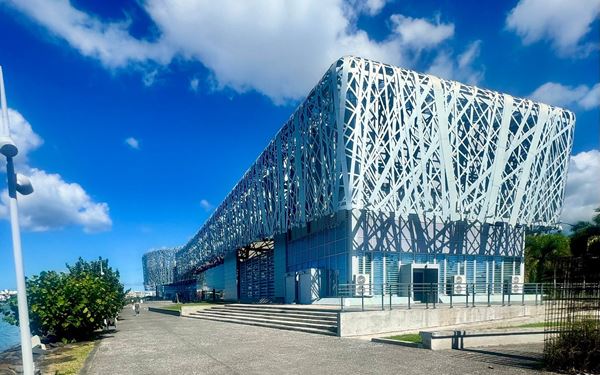The Mémorial ACTe is a landmark museum and cultural center dedicated to the history of the slave trade and the resilience of the Caribbean people. Its striking modern architecture overlooks the Caribbean Sea. Inside, powerful exhibits use art and technology to tell the stories of the African diaspora, making it a significant site for reflection and understanding the complex history of Guadeloupe.