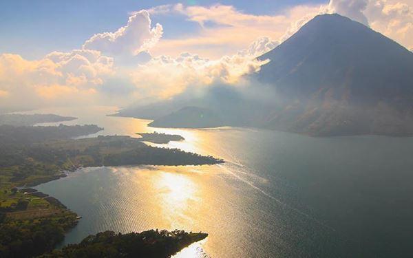 Lake Atitlán is a stunning crater lake surrounded by three towering volcanoes and traditional Mayan villages. Often called one of the most beautiful lakes in the world, it is a hub for indigenous culture and spiritual retreats. Visitors can explore villages like Panajachel and Santiago Atitlán, experiencing the vibrant textiles, local markets, and breathtaking natural scenery of the highlands.