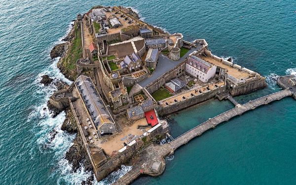 Castle Cornet is an 800-year-old fortress that has guarded the mouth of St. Peter Port harbor for centuries. The castle features five museums that cover local history, maritime life, and military heritage. Visitors can explore the ancient battlements, enjoy the period gardens, and witness the daily firing of the noonday gun, offering a fascinating journey through Guernsey's strategic maritime past.