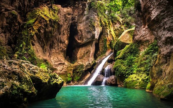 Bassin Bleu is a hidden gem near Jacmel, featuring a series of three deep, turquoise pools connected by waterfalls hidden behind lush vegetation. Legend says that goddesses live in the caves behind the falls. It is a tranquil and magical oasis where visitors can swim in the cool, clear water, offering a peaceful escape and a chance to experience the incredible natural beauty of the Haitian landscape.