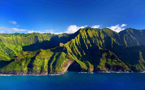 Located on Kauai, the Na Pali Coast is famous for its towering emerald cliffs, hidden sea caves, and cascading waterfalls. Accessible only by boat, helicopter, or a challenging hike, its rugged and majestic beauty is unparalleled. The dramatic landscape, featured in many movies, represents the wild and untouched heart of Hawaii, offering a breathtaking experience of nature’s grandeur along the Pacific.