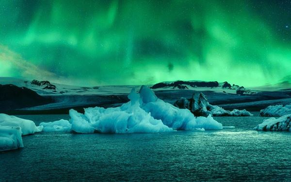 Jökulsárlón is a stunning lagoon filled with blue icebergs that have broken off from the Breiðamerkurjökull glacier. The icebergs slowly float toward the ocean and often wash up on the nearby Diamond Beach. Visitors can take boat tours to see the ice up close. It is an ethereal and constantly changing landscape that highlights Iceland’s dramatic and icy volcanic nature.