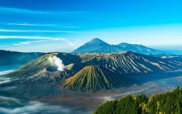 Mount Bromo is an active volcano in East Java, famous for its surreal, lunar-like landscape and breathtaking sunrises. Visitors can hike or take a jeep across the "Sea of Sand" to reach the crater rim. The sight of Bromo smoking alongside the higher Mount Semeru at dawn is one of the most iconic and awe-inspiring natural views in all of Southeast Asia.