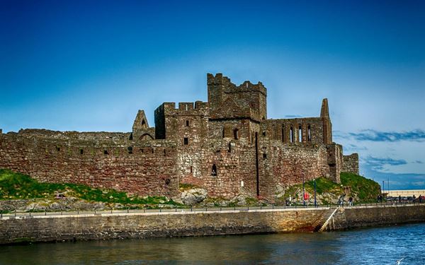 Peel Castle is a majestic ruin located on St Patrick's Isle, connected to the mainland by a causeway. Originally built by Vikings in the 11th century, it features ancient cathedrals, round towers, and massive curtain walls. The castle’s dramatic seaside location makes it a perfect spot for sunset views and spotting seals and basking sharks in the clear waters of the Irish Sea.