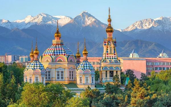 Almaty, the former capital, is a green city at the foot of the Trans-Ili Alatau mountains. The Zenkov Cathedral, located in Panfilov Park, is a stunning 19th-century wooden church built without a single nail. The city blends Soviet-style architecture with modern cafes and is the gateway to high-altitude adventures at Medeu and Shymbulak, offering a mix of history and alpine beauty.