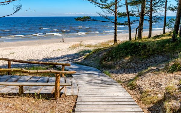 Jūrmala is Latvia's premier seaside resort, famous for its 33-kilometer stretch of white quartz sand and its unique wooden Art Nouveau villas. Surrounded by pine forests, the beach offers a refreshing and therapeutic environment. It is a popular summer destination for swimming and cultural events, providing a relaxed and elegant coastal atmosphere just a short train ride from the capital, Riga.