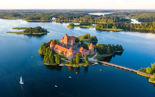 Trakai Island Castle is a stunning 14th-century brick fortress located on an island in Lake Galvė. It is the only island castle in Eastern Europe and served as a residence for the Grand Dukes of Lithuania. Surrounded by blue water and lush greenery, it offers a magical medieval atmosphere and houses a fascinating history museum.