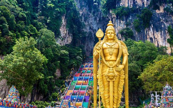 Batu Caves is a massive limestone hill featuring a series of caves and cave temples, dominated by a giant golden statue of Lord Murugan. Visitors must climb 272 colorful steps to reach the main Temple Cave. It is one of the most important Hindu shrines outside of India, offering a vibrant mix of religious devotion, playful monkeys, and impressive natural geological formations.