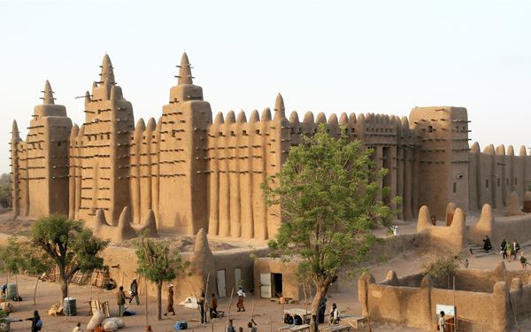 The Great Mosque of Djenné is the largest mud-brick building in the world and a masterpiece of Sudano-Sahelian architecture. Every year, the entire community participates in the "Crepissage" to replaster the mosque with mud. This UNESCO site stands as a powerful symbol of Islamic faith and West African heritage, reflecting the historical importance of Djenné as a center of trade and scholarship.