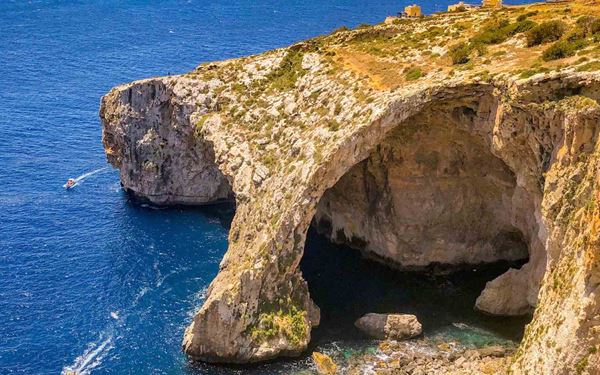 The Blue Grotto is a complex of seven sea caves on the southern coast of Malta, famous for its brilliant turquoise waters. Boat tours take visitors inside the caves to witness the stunning light reflections and vibrant marine life against the rocky walls. The massive natural arch and the clarity of the water make it a premier destination for photography, diving, and experiencing the island's natural coastal beauty.