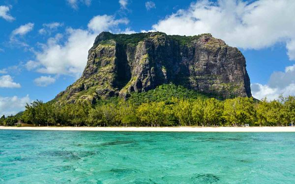 Le Morne Brabant is a majestic basaltic mountain and a UNESCO World Heritage site that served as a refuge for runaway slaves in the 18th and 19th centuries. The mountain is a symbol of freedom and resilience. Hiking to the summit offers spectacular views of the famous "underwater waterfall" illusion in the ocean, making it a place of both profound historical significance and natural beauty.