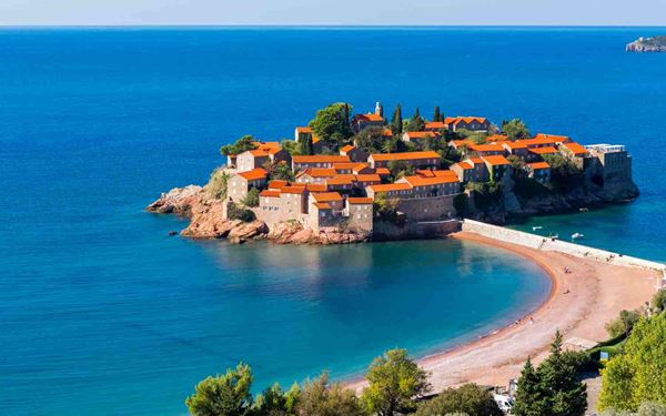 Sveti Stefan is a picturesque fortified island village connected to the mainland by a narrow tombolo. Once a 15th-century fishing village, it is now an world-famous luxury resort known for its pink-sand beaches and red-roofed stone villas. Its iconic silhouette against the turquoise Adriatic Sea makes it the most photographed site in Montenegro and a symbol of Mediterranean elegance.