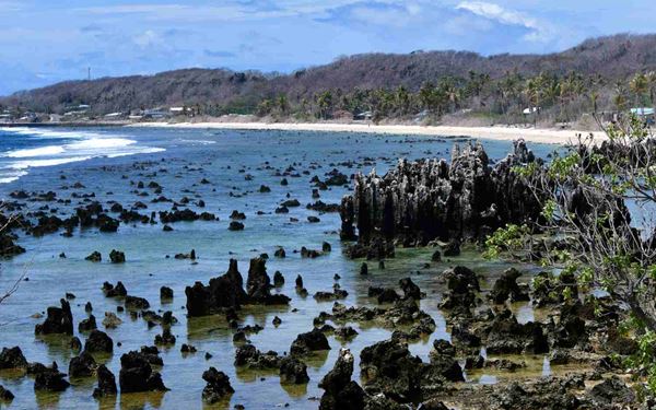 Anibare Bay is Nauru's most beautiful coastal area, featuring a stunning white-coral sand beach and clear blue waters. It is the best spot on the island for swimming and enjoying the tropical sun. The bay is framed by dramatic limestone pinnacles and the Anibare Harbor, offering a tranquil and picturesque environment in one of the world's smallest and most remote nations.