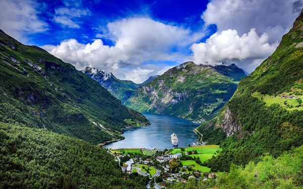 Geirangerfjord is a UNESCO World Heritage site and one of Norway’s most famous fjords, known for its deep blue water and dramatic waterfalls like the Seven Sisters. Surrounded by steep, snow-capped mountains, it offers breathtaking views from viewpoints like Dalsnibba. A cruise through the fjord provides an unforgettable experience of Norway’s majestic and untouched natural beauty.