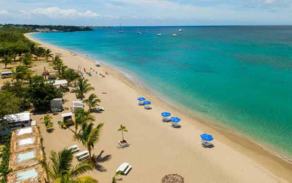 Located on the island of Nevis, Pinney’s Beach is a stunning four-mile stretch of golden sand lined with coconut palms. The calm, turquoise waters are perfect for swimming and snorkeling. It is home to iconic beach bars like Sunshine’s, offering a relaxed and authentic Caribbean vibe with spectacular sunset views over the neighboring island of Saint Kitts.