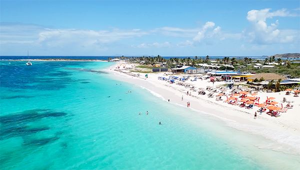 Orient Bay Beach, known as the "Saint-Tropez of the Caribbean," is a vibrant and expansive white-sand beach on the French side of the island. It offers a wide range of water sports, from jet skiing to paragliding, and is lined with chic beach clubs and restaurants. The lively atmosphere and turquoise waters make it the premier spot for sun-seekers and luxury lovers.