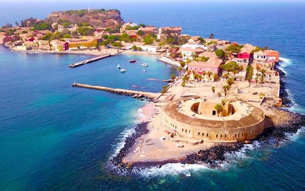 Gorée Island is a UNESCO World Heritage site known for its dark history as one of the largest slave-trading centers on the African coast. The "House of Slaves" with its "Door of No Return" serves as a powerful memorial. Today, the island is a peaceful, car-free place with colorful colonial houses and vibrant bougainvillea, offering a profound journey into history and a serene coastal atmosphere.