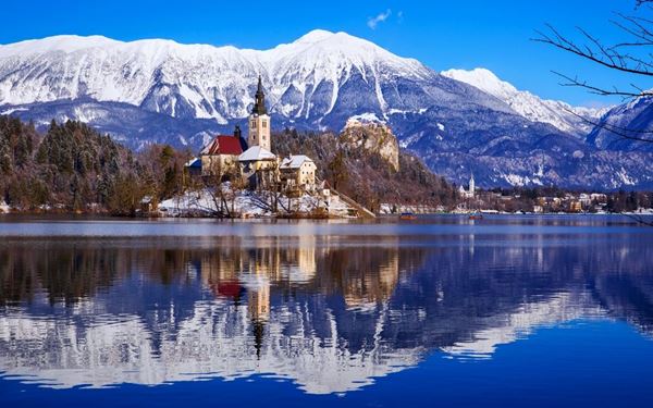 Lake Bled is a fairytale destination featuring an emerald-green lake with a small island and a church in its center. Overlooked by a medieval castle perched on a cliff, it is the most iconic sight in Slovenia. Visitors can take a traditional "pletna" boat to the island or walk the path around the lake for breathtaking views, experiencing a perfect blend of history and alpine beauty.