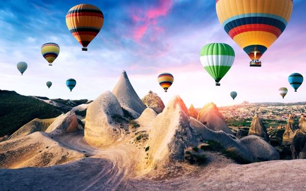 Cappadocia is world-famous for its unique "fairy chimney" rock formations and ancient cave dwellings. The landscape is most spectacular when viewed from a hot air balloon at sunrise. Visitors can explore underground cities like Derinkuyu and stay in traditional cave hotels, experiencing one of the most surreal and historically rich regions on the planet.