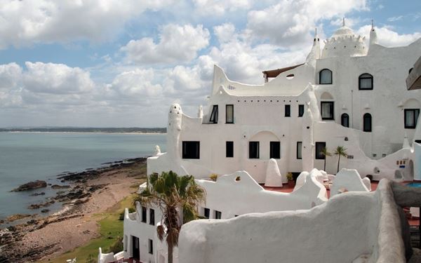 Casapueblo is a spectacular "living sculpture" and former home of artist Carlos Páez Vilaró, located on the cliffs of Punta Ballena. Its unique, whitewashed Mediterranean-style architecture resembles the Greek islands. Now a museum, gallery, and hotel, it is famous for its daily "Sun Ceremony" where a poem is read as the sun sets over the ocean. It is an artistic masterpiece that offers one of the most magical views in Uruguay.