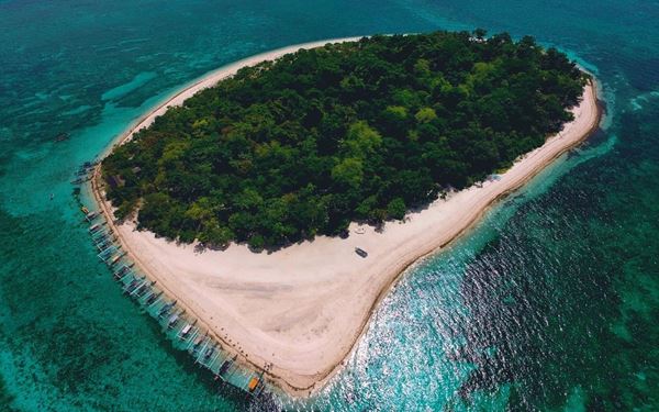 Buck Island is a small, uninhabited island off St. Croix that features one of only three underwater national monuments in the US. Its massive elkhorn coral barrier reef creates a vibrant lagoon teeming with tropical fish and sea turtles. Accessible only by boat, it offers a premier snorkeling and diving experience, showcasing a spectacular and well-preserved marine ecosystem in a remote, pristine setting.