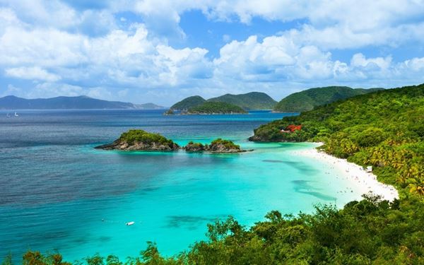 Trunk Bay is world-famous for its pristine white sand and its unique underwater snorkeling trail, where plaques identify the coral and sea life. Located within the Virgin Islands National Park, it is widely considered one of the most beautiful beaches in the Caribbean. The combination of lush green hills and crystal-clear water makes it a paradise for nature lovers and a symbol of the islands' protected natural beauty.