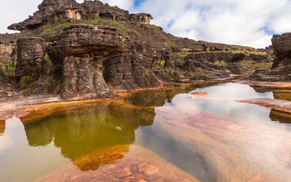 Mount Roraima is a massive "tepui" (tabletop mountain) located at the junction of Venezuela, Brazil, and Guyana. Its sheer 400-meter cliffs and flat summit, often covered in clouds, inspired Arthur Conan Doyle’s "The Lost World." Hiking to the top reveals a surreal landscape of quartz crystals, unique carnivorous plants, and strange rock formations. It is an ancient and mystical destination that offers a true journey to another world.